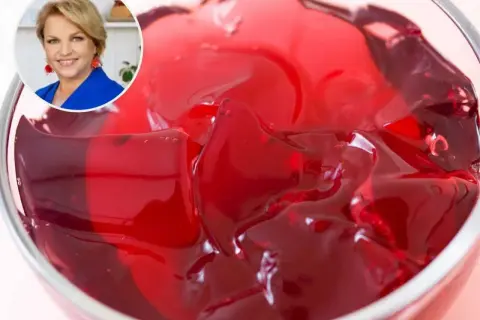 Kobieta w okręgu i miska z czerwonym, tężejącym deserem galaretkowym.