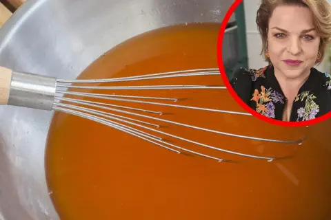 Kobieta w okręgu nad miską z pomarańczowym płynem i trzepaczką.